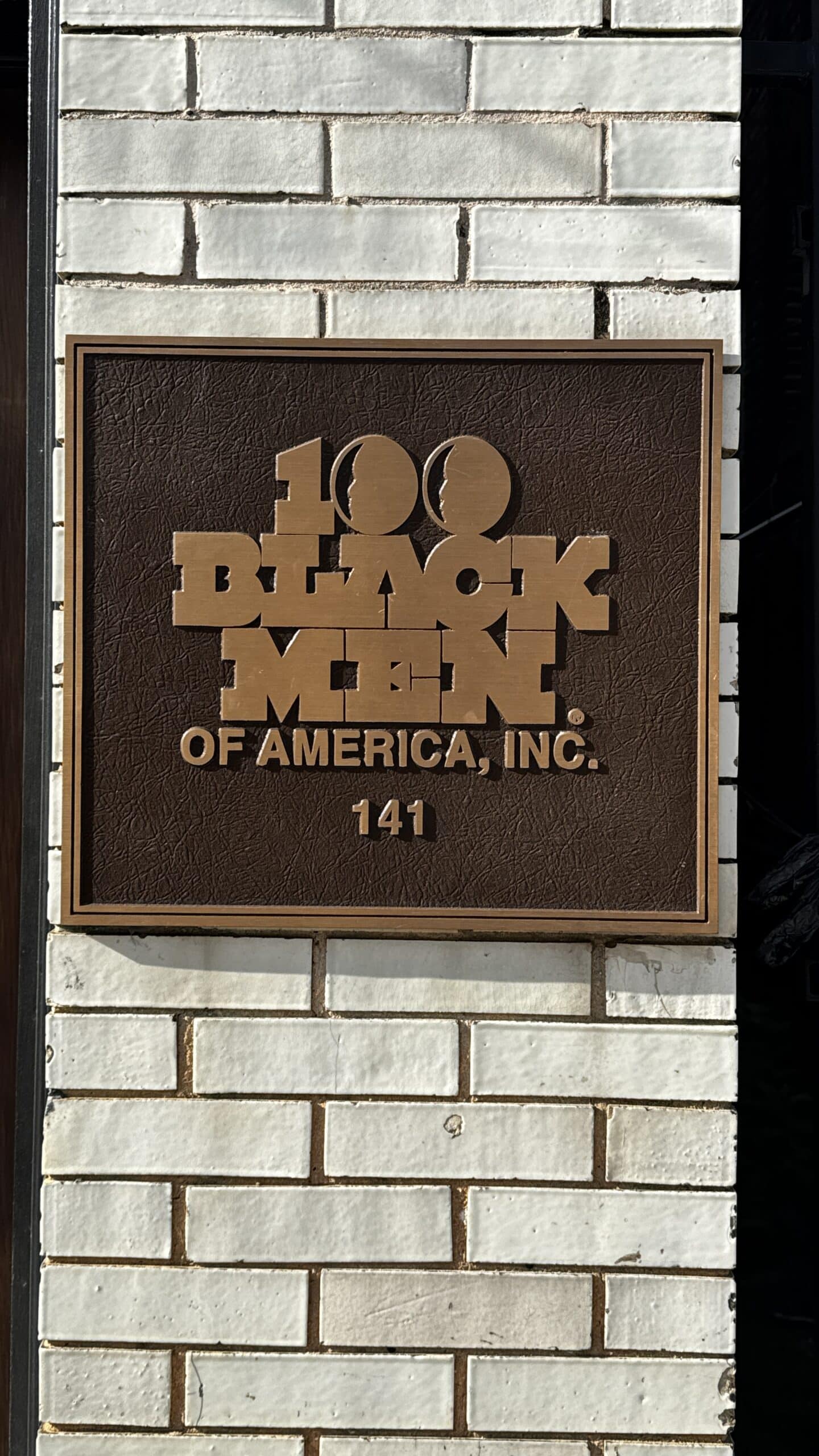 Photo of a wall plaque/award reading "100 Black Men of America, Inc."
